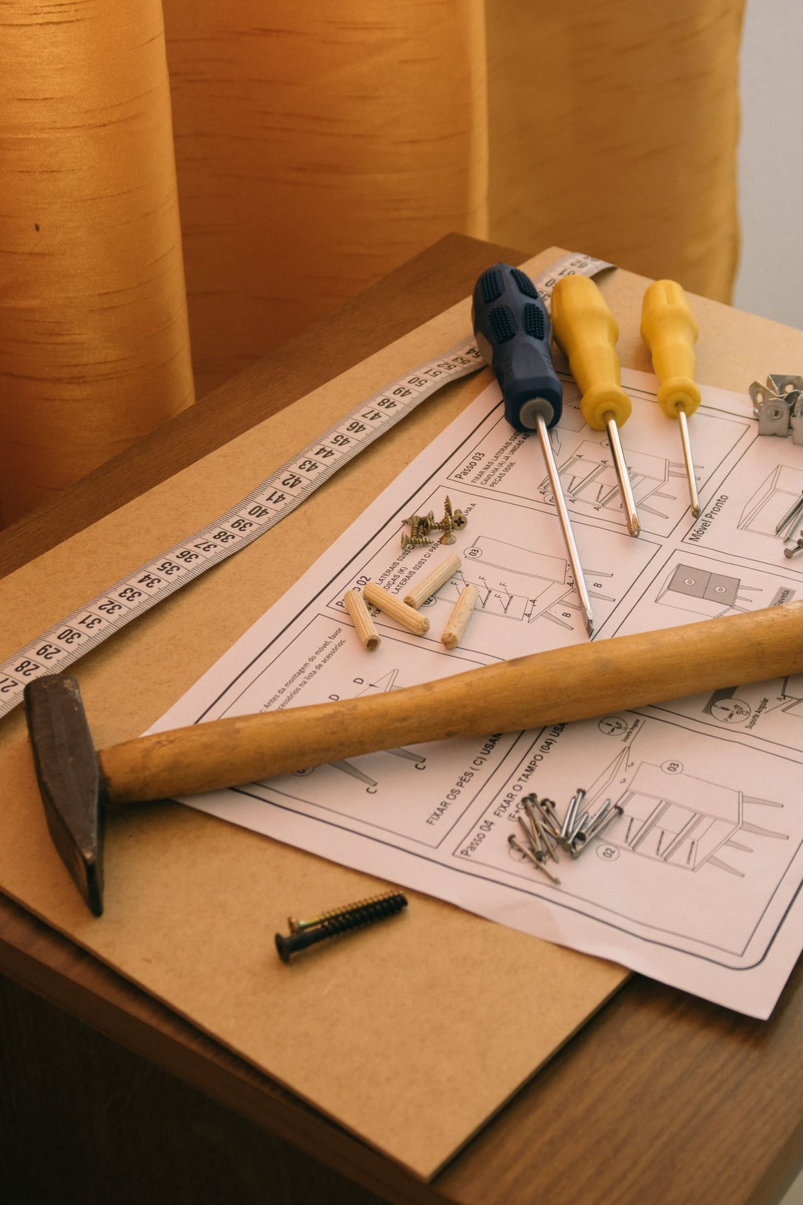 Screwdrivers, a hammer and screws on furniture assembly instructions