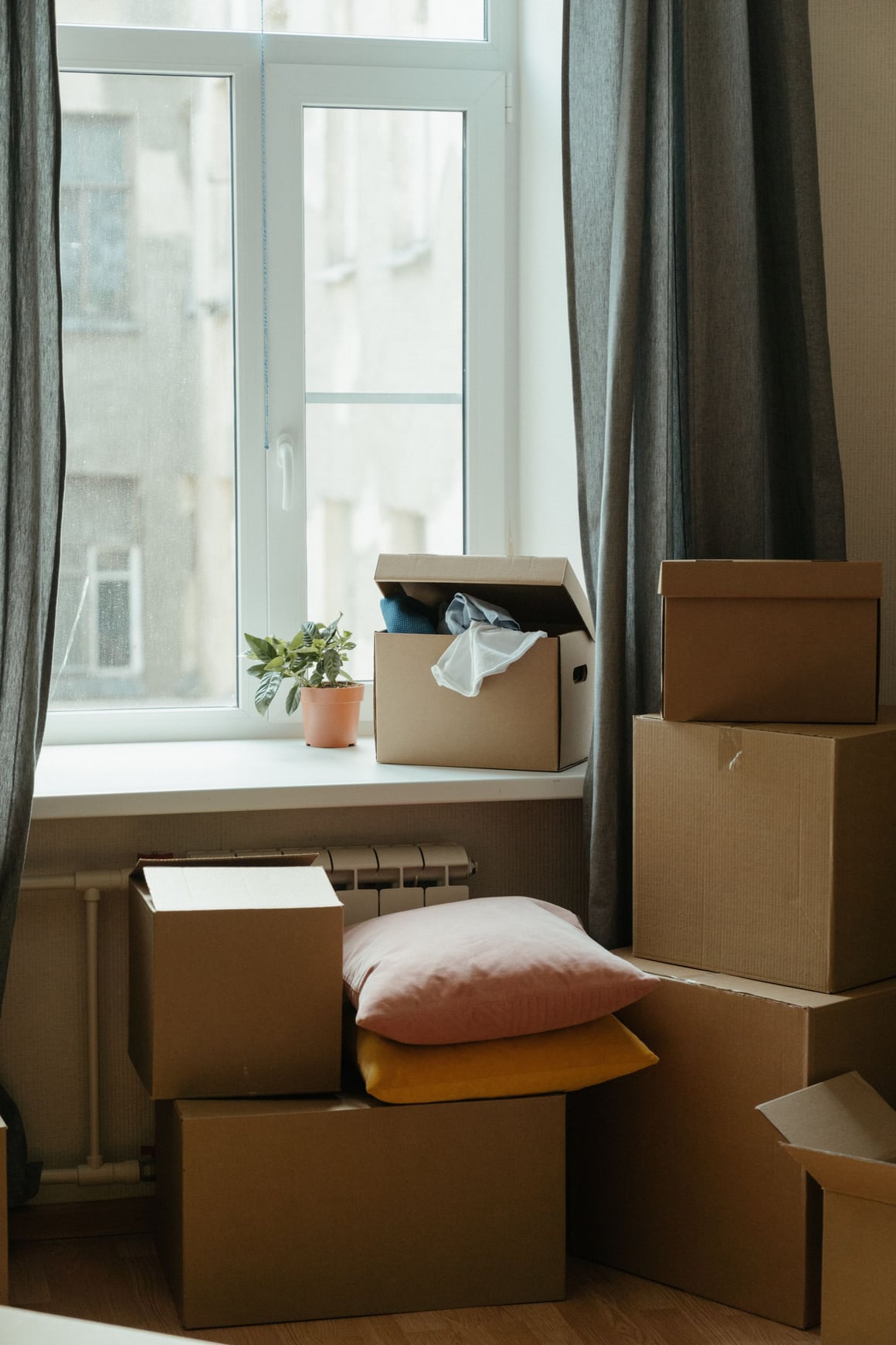 Cardboard boxes stacked beside a window