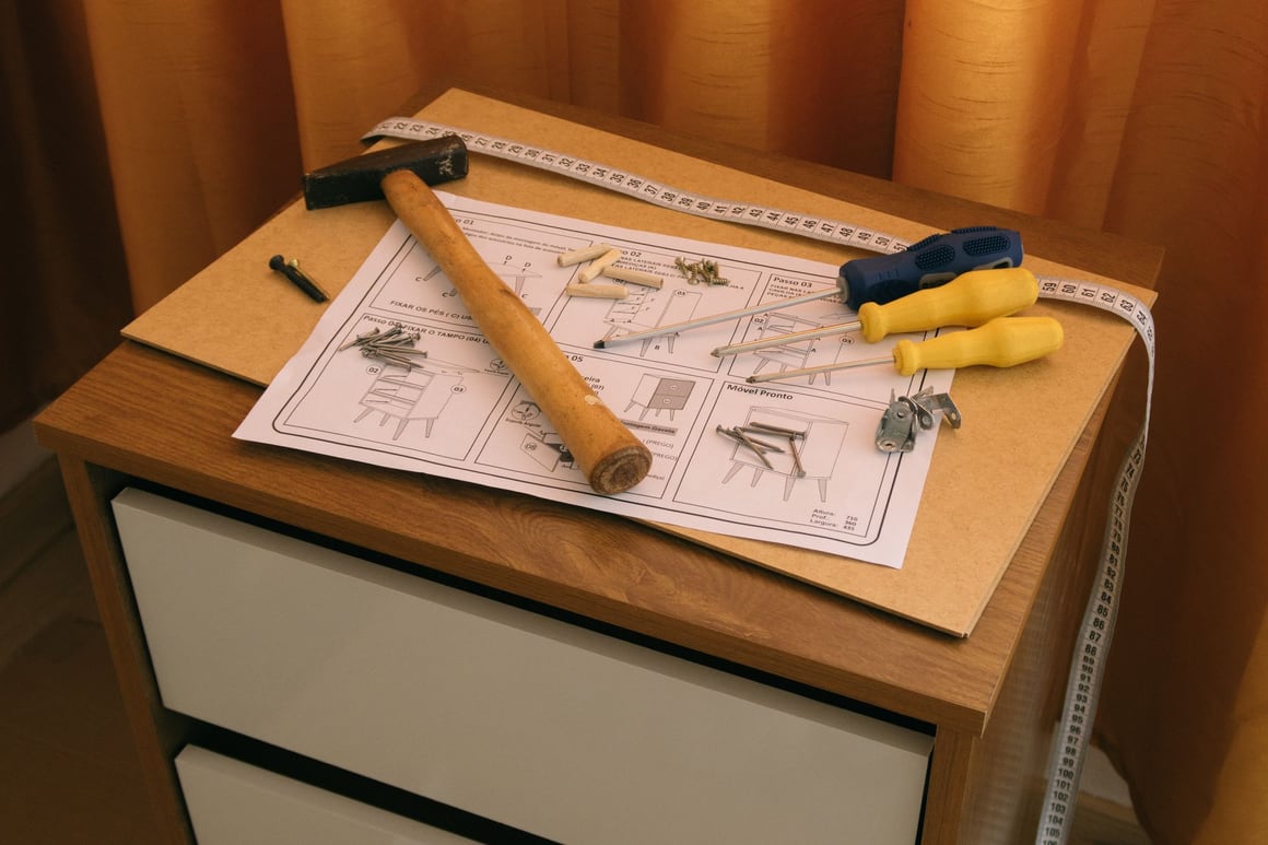 A hammer, screwdrivers and measuring tape on cabinet assembly instructions